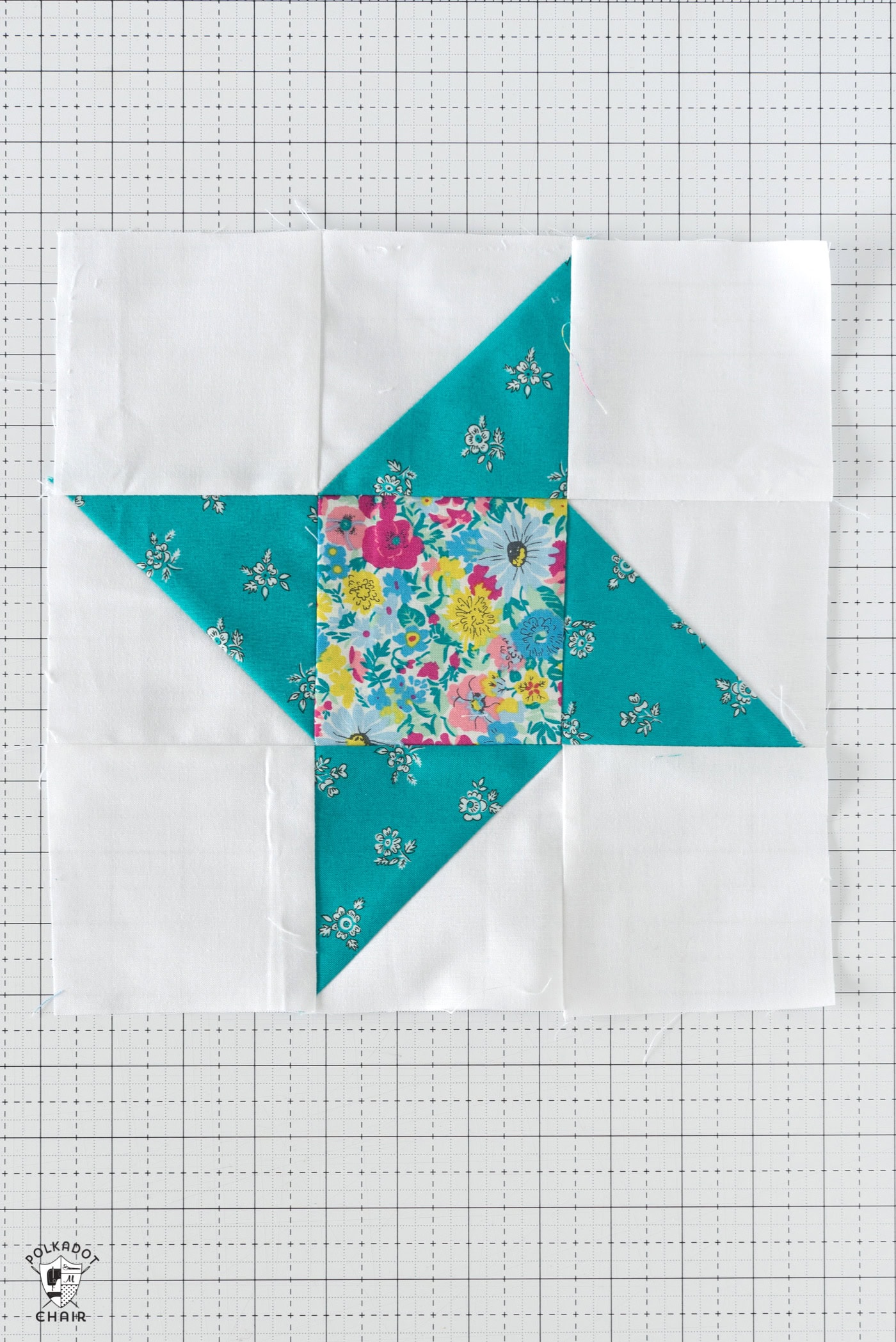 blue and floral quilt block on white cutting mat