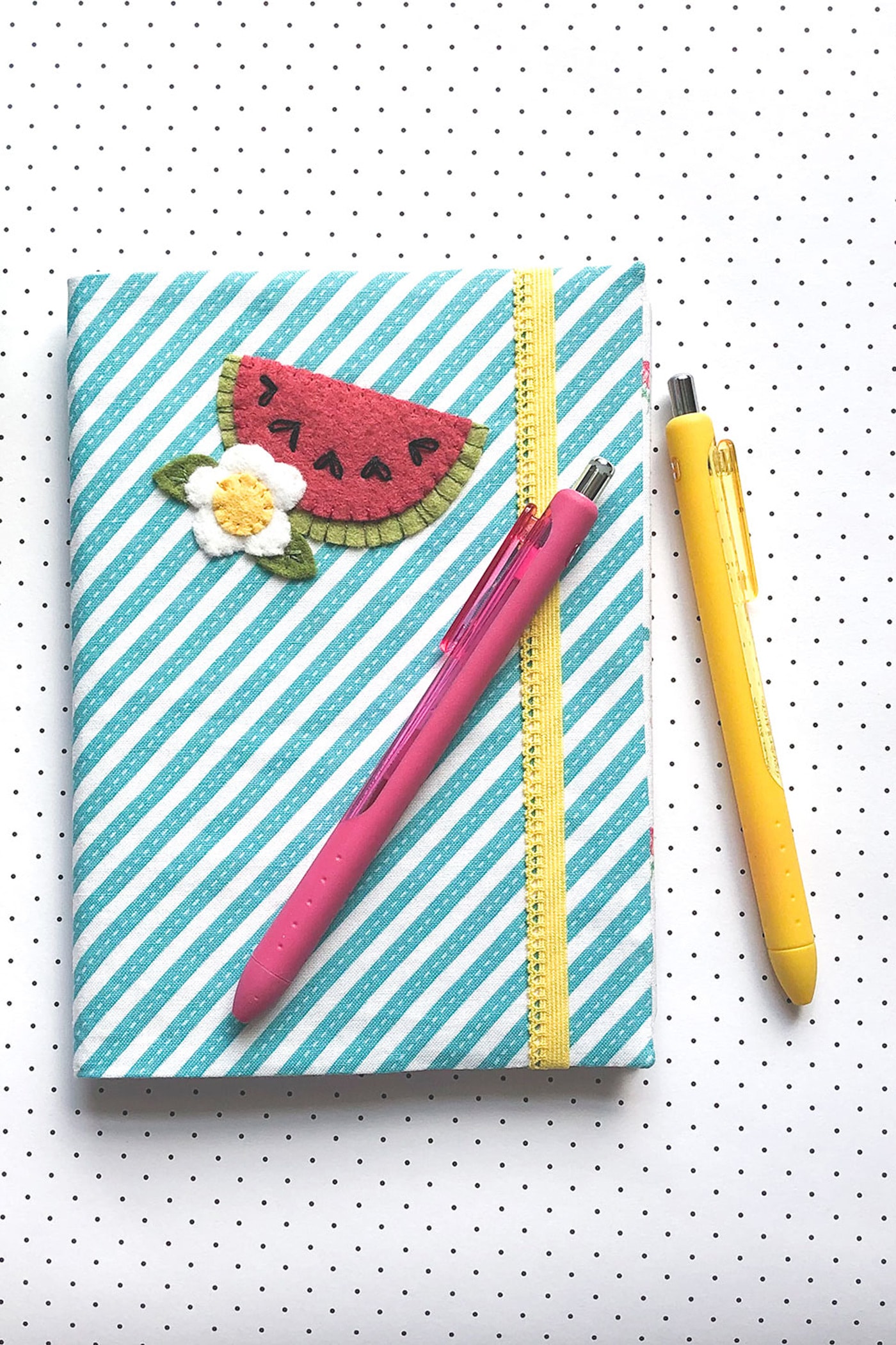 blue and white striped note book on white & black polka dot tablecloth