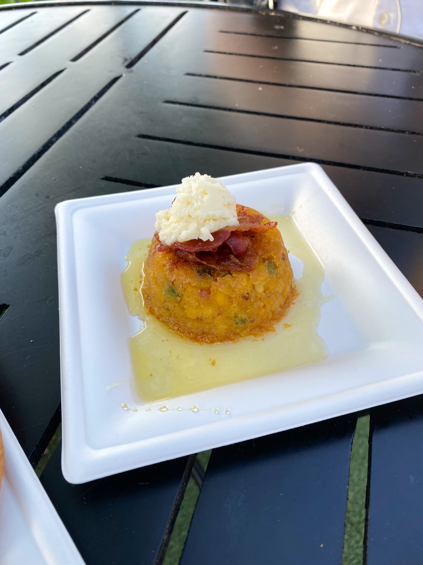 honey spoon bread on white plate on black table