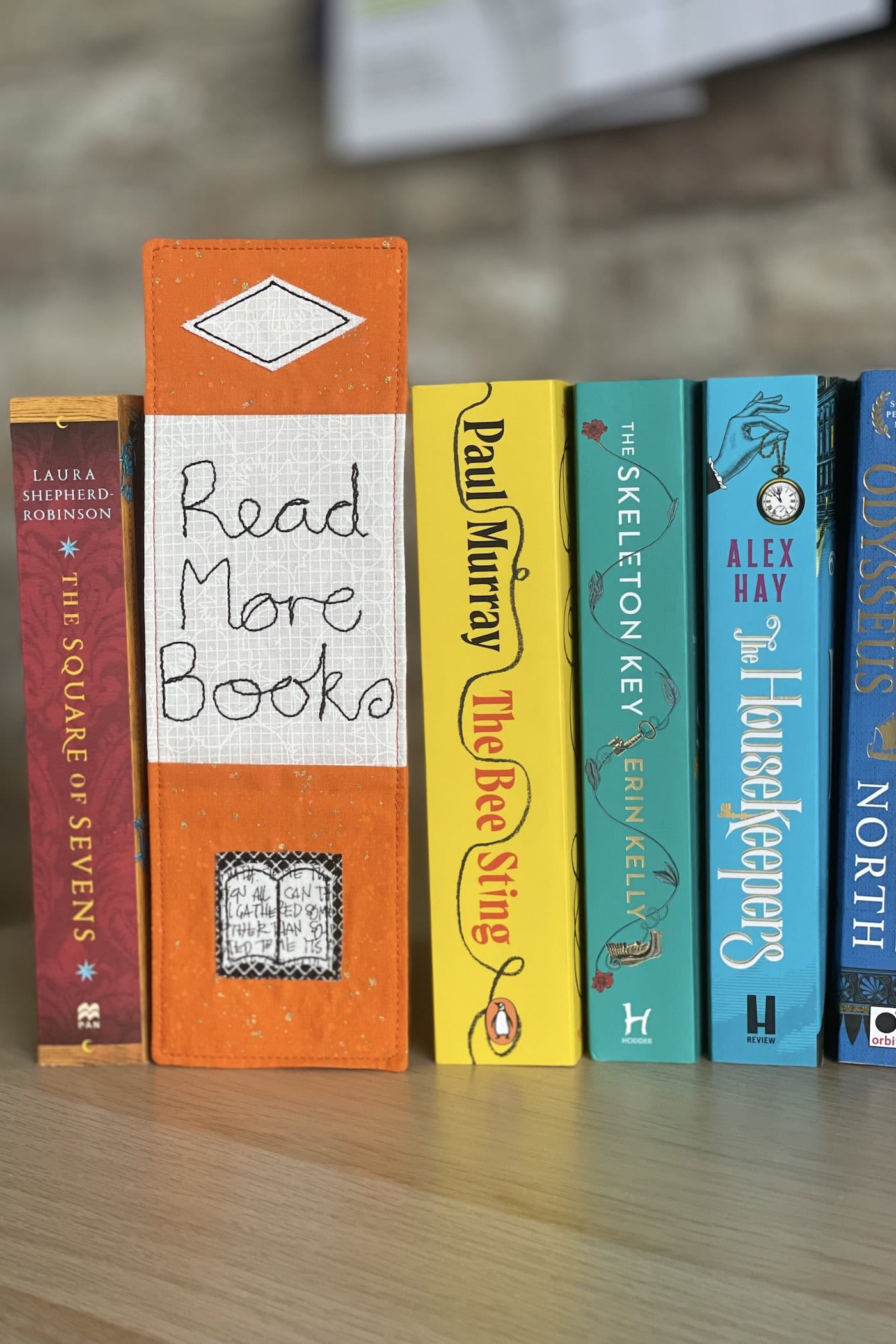 orange bookmark on book on wood table with other books