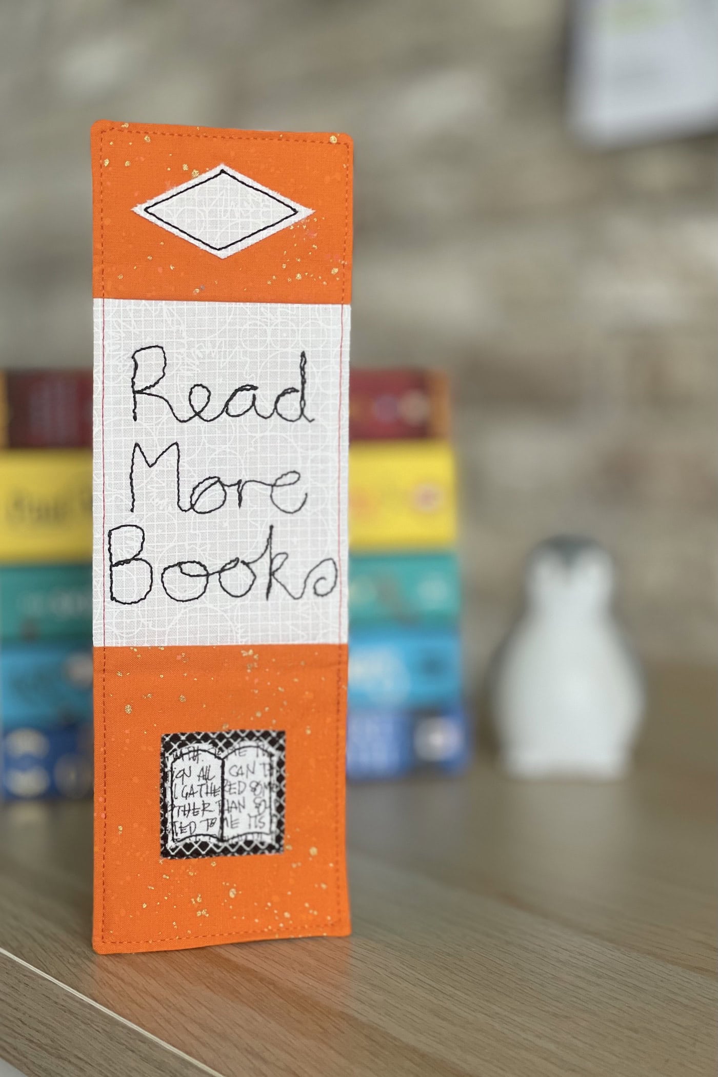 orange bookmark on book on wood table with other books