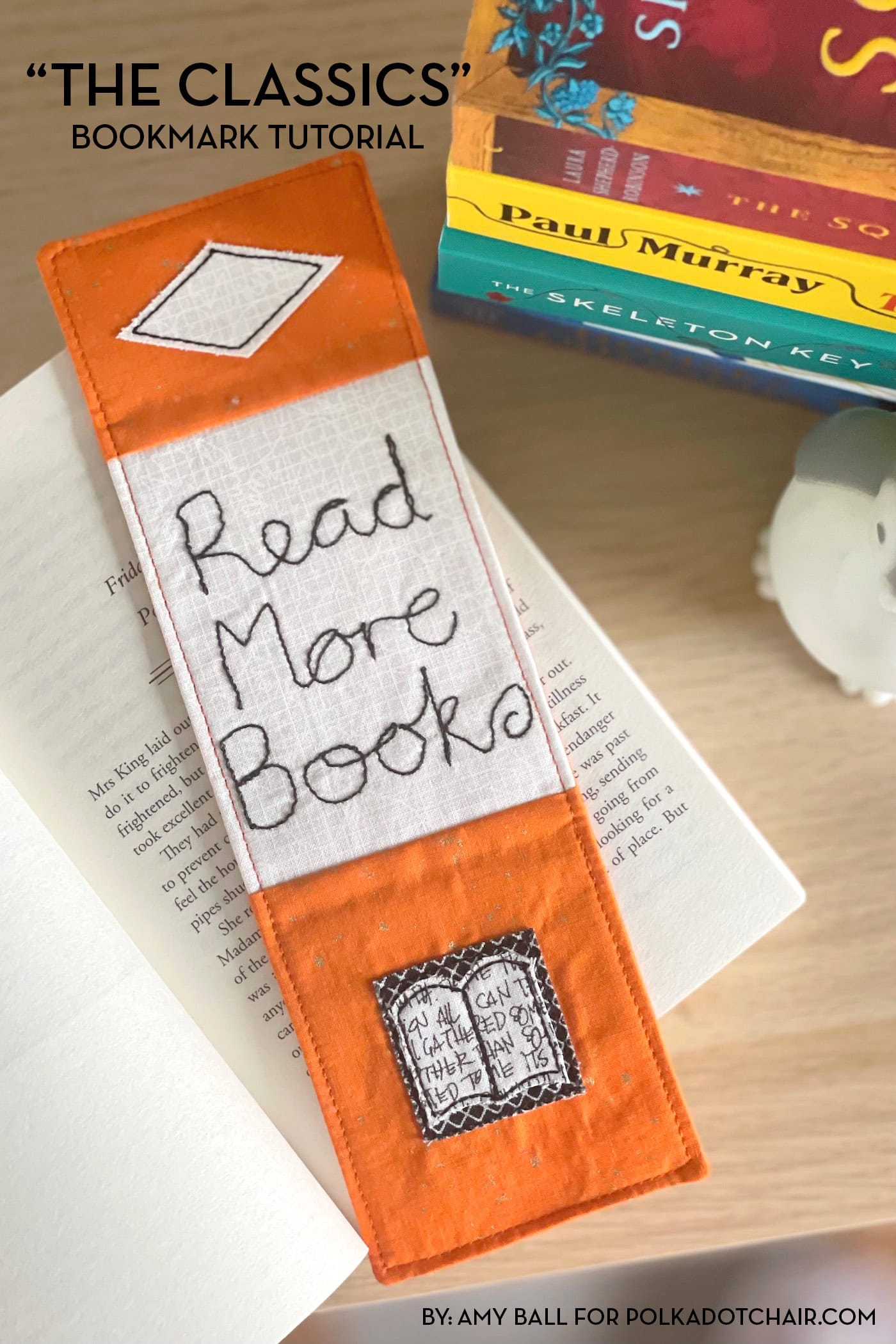 orange bookmark on book on wood table with other books