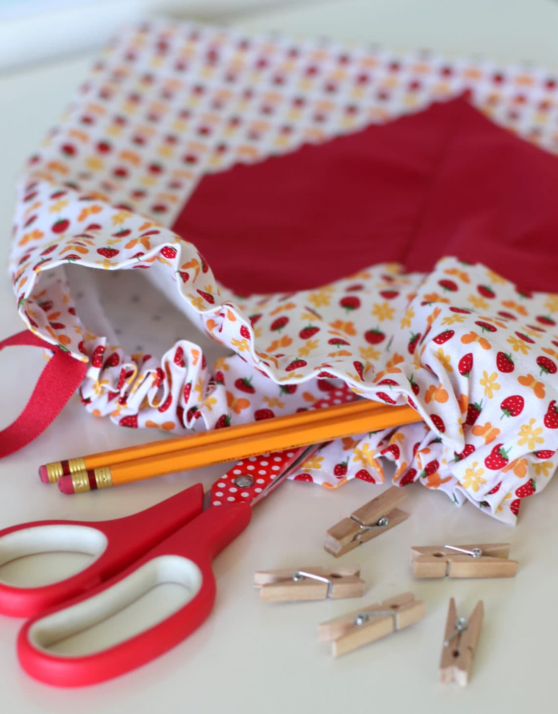 drawstring bag with heart on table with school supplies