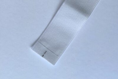 gray zippered bookmark construction process photo - fabric on white table with sewing notions