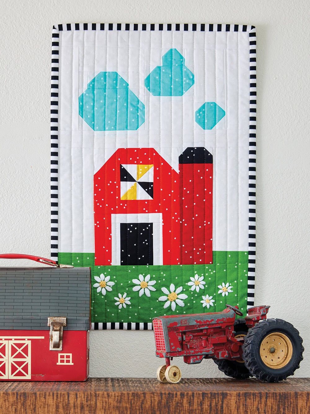 Barn quilt block on wall with farm toys