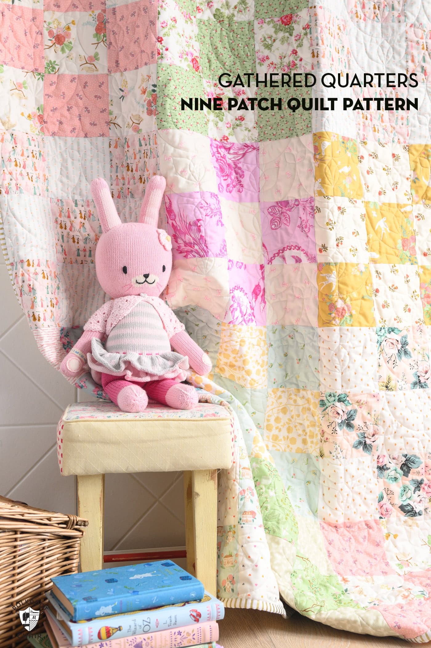 pink, green, yellow and ivory patchwork quilt on wall with toys in the foreground