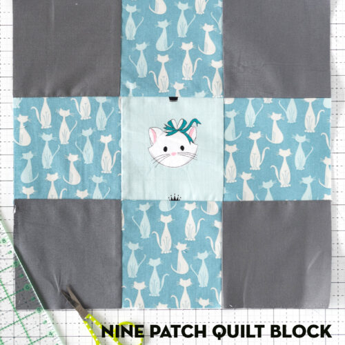 Blue and gray nine patch quilt block on white cutting mat with sewing notions