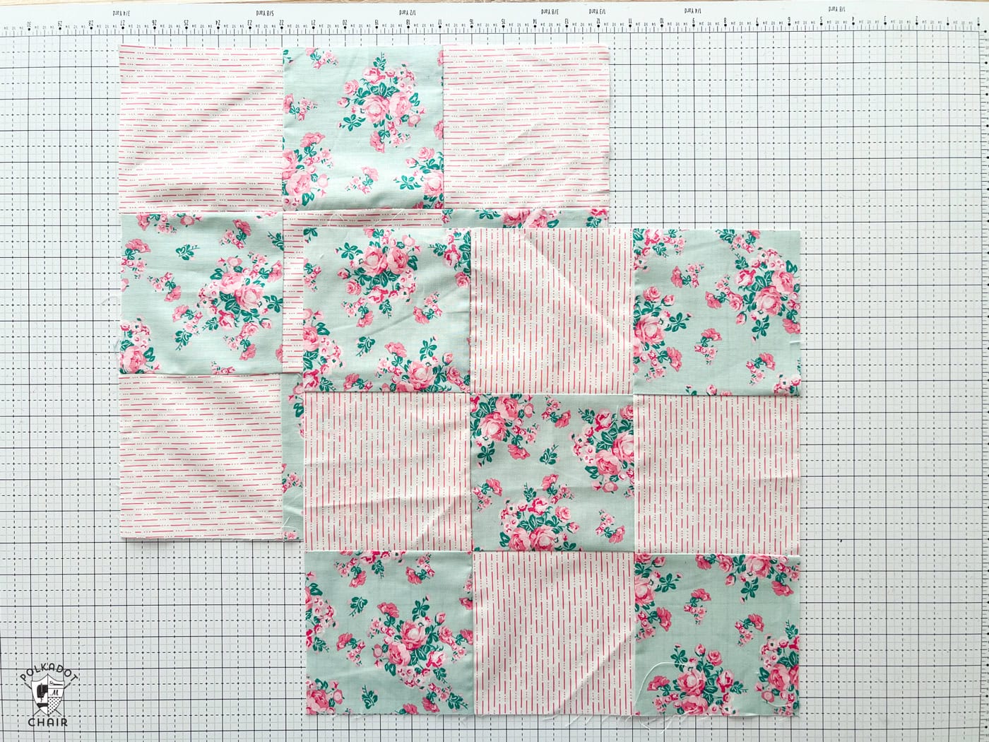 pink and blue quilt blocks on white cutting mat